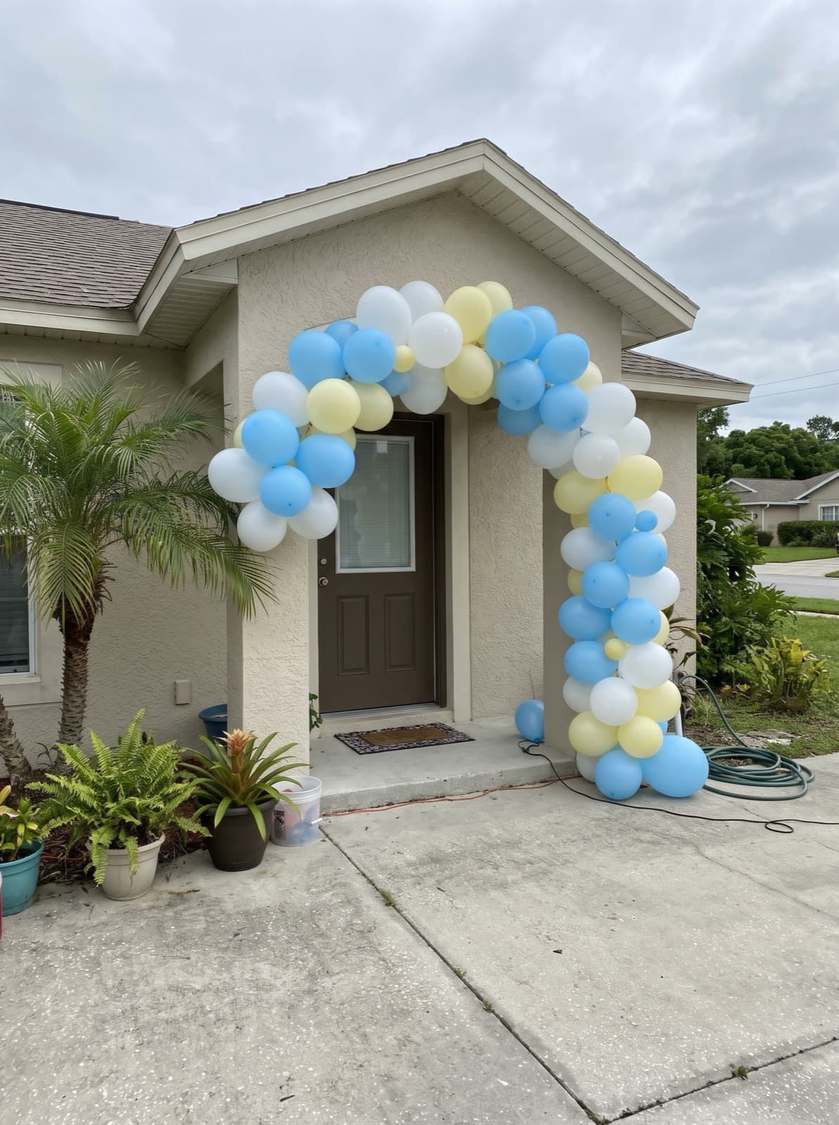 Balloon arch over the front door of a stucco home
