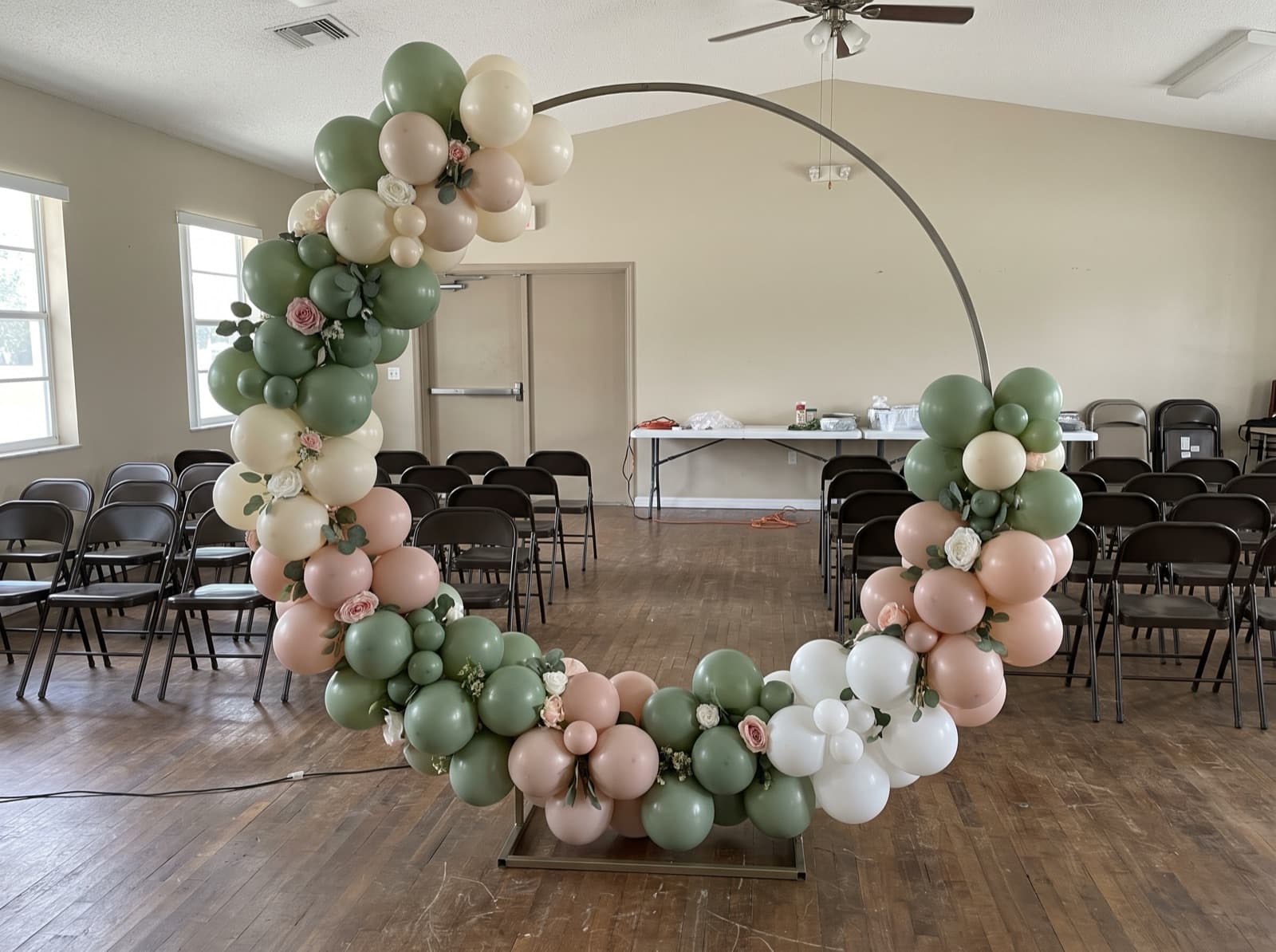 Round balloon arch with silk florals framing a photo spot