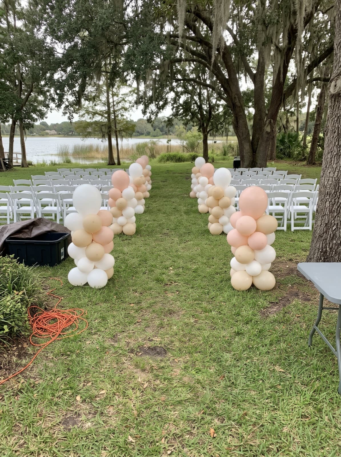 Organic balloon columns lining a ceremony aisle