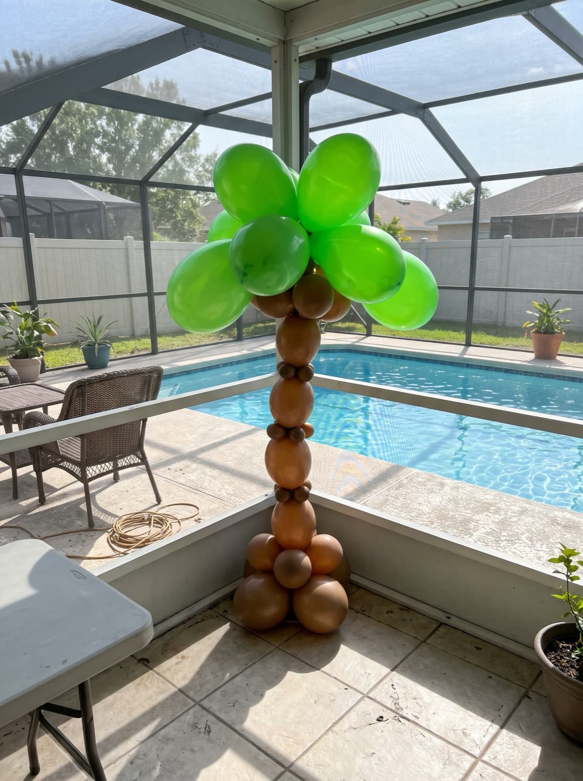 Palm tree balloon column beside a pool
