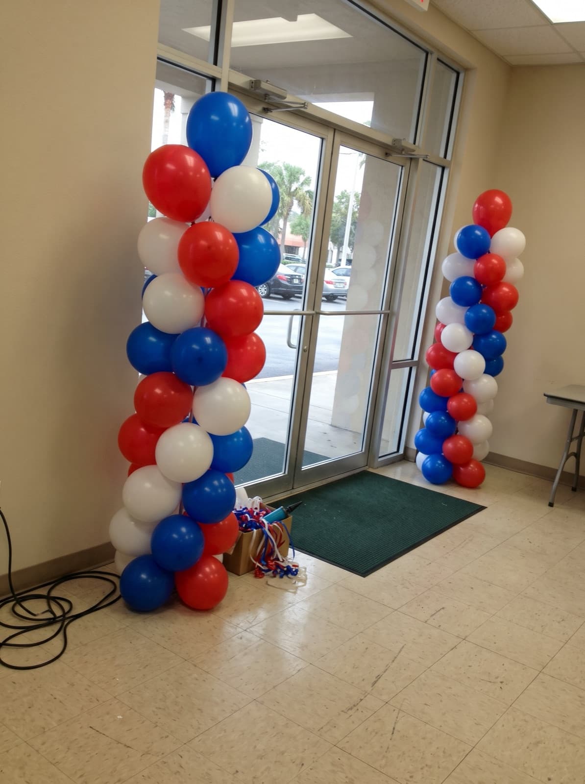 Red, white and blue spiral balloon columns at an office lobby