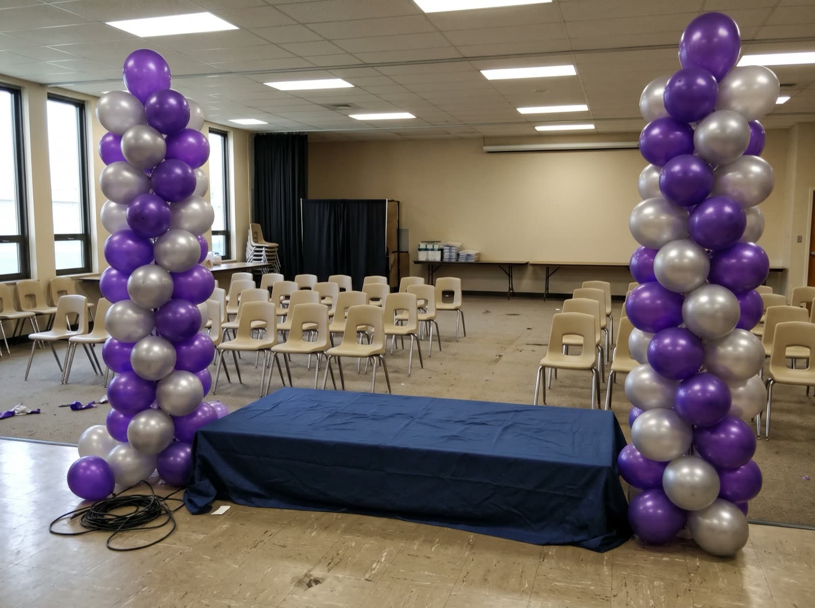 Tall balloon columns on each side of a stage