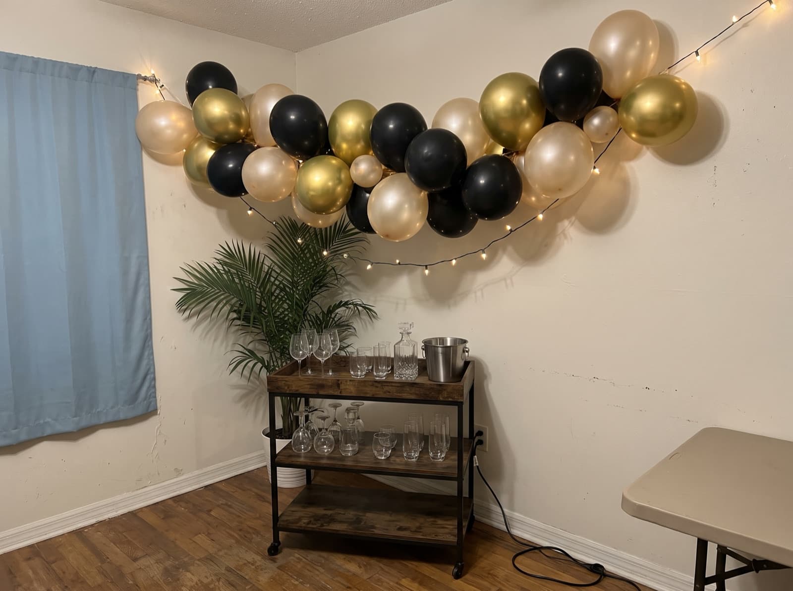 Chrome gold and black balloon garland over a bar cart