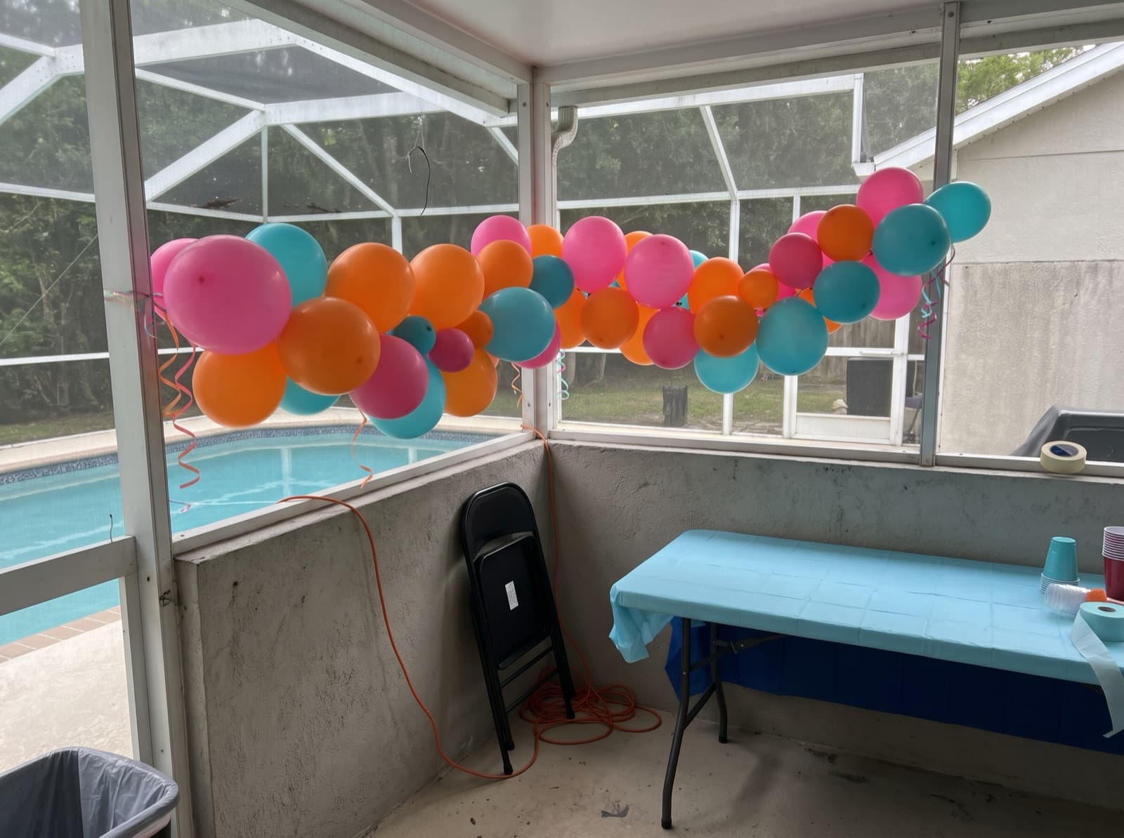 Balloon garland tied along a screened pool enclosure