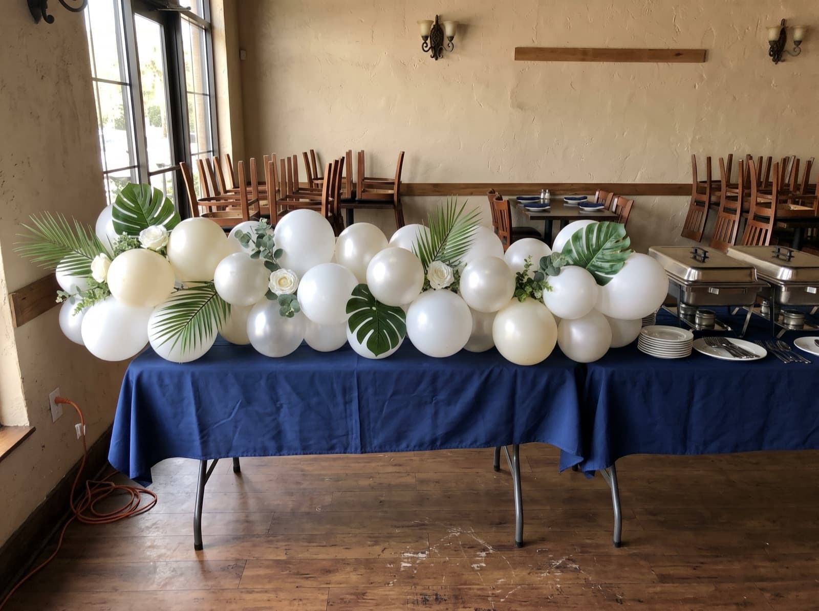 Balloon garland with palm leaves and silk flowers