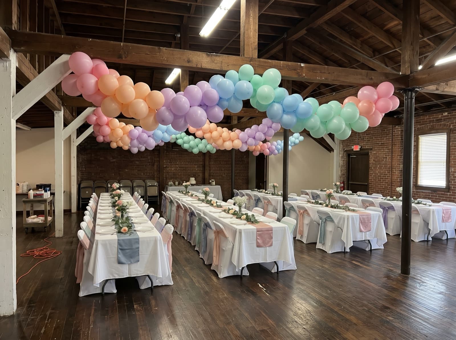 Hanging balloon garland canopy over dining tables