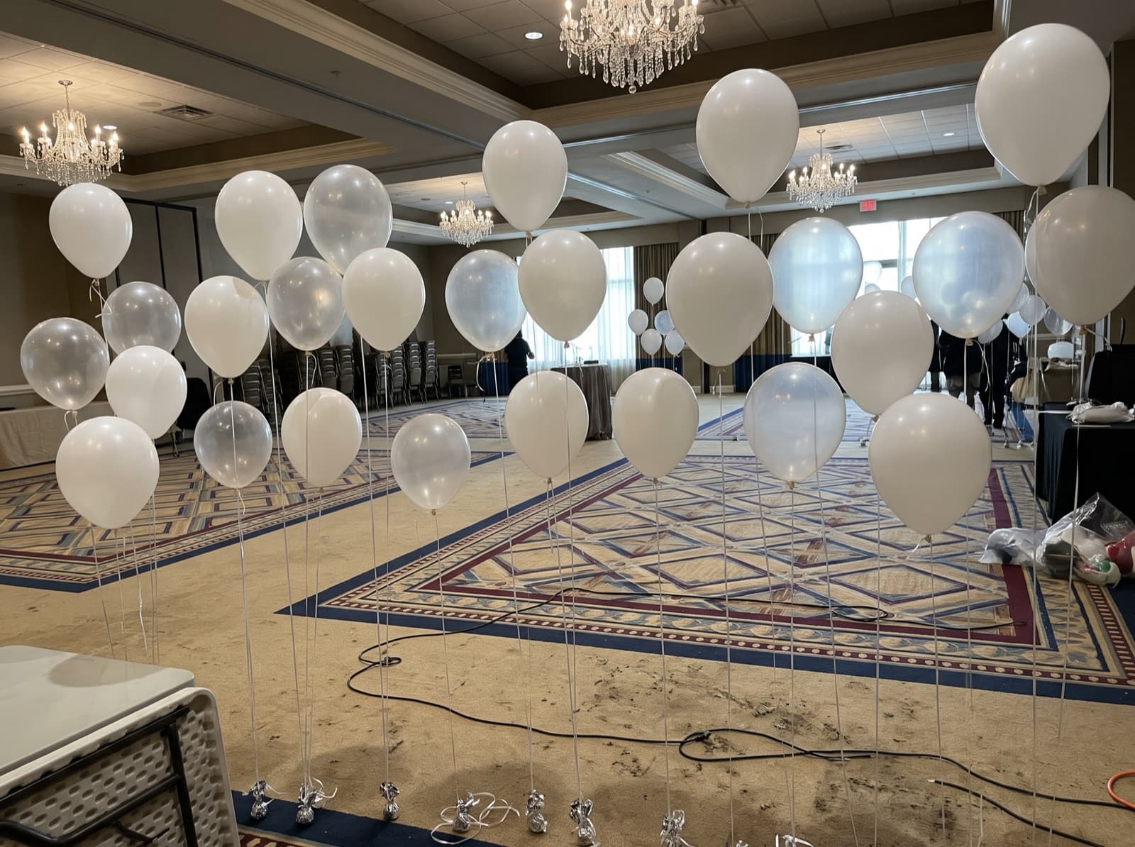 Floating helium balloon wall with ribbons in a ballroom