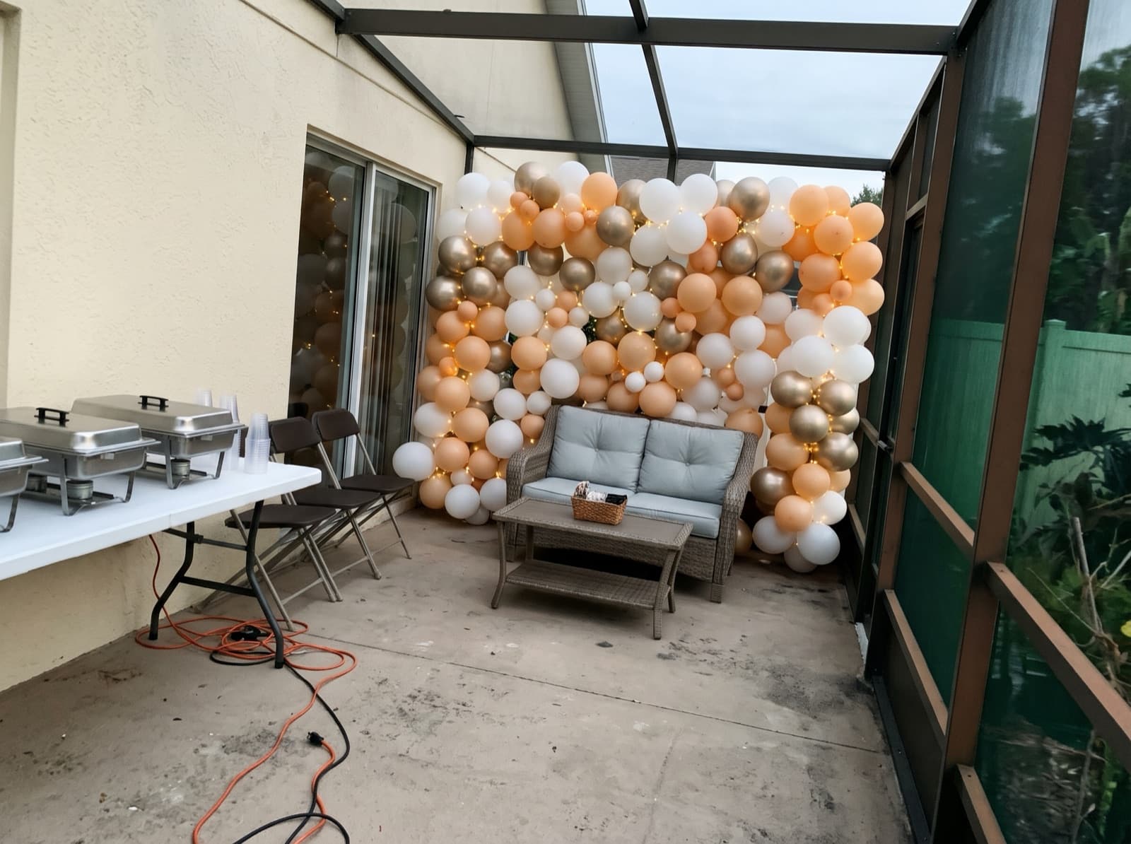Balloon wall with string lights on a covered lanai
